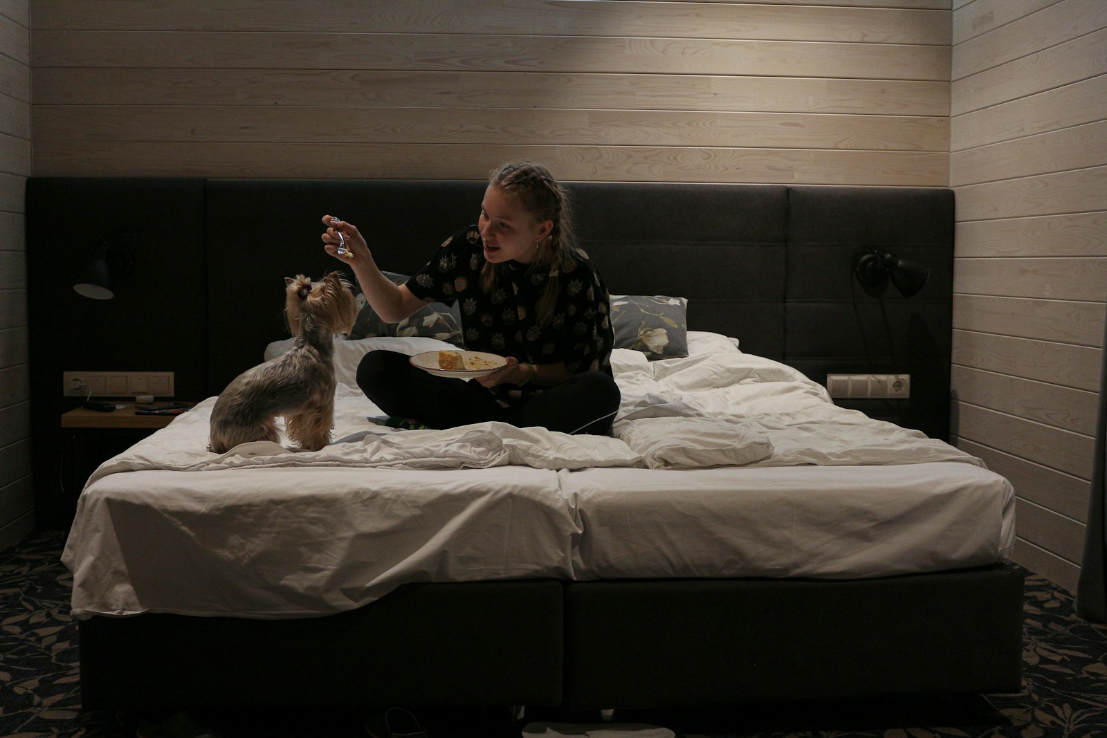 woman in black and white floral long sleeve shirt sitting on bed